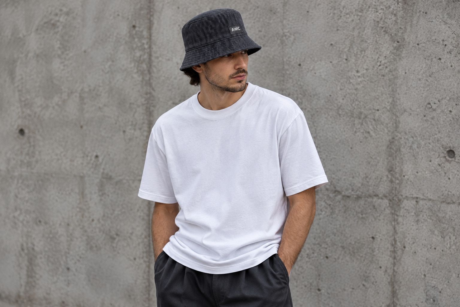 Black-on-black bucket hat worn with a plain tee and relaxed trousers