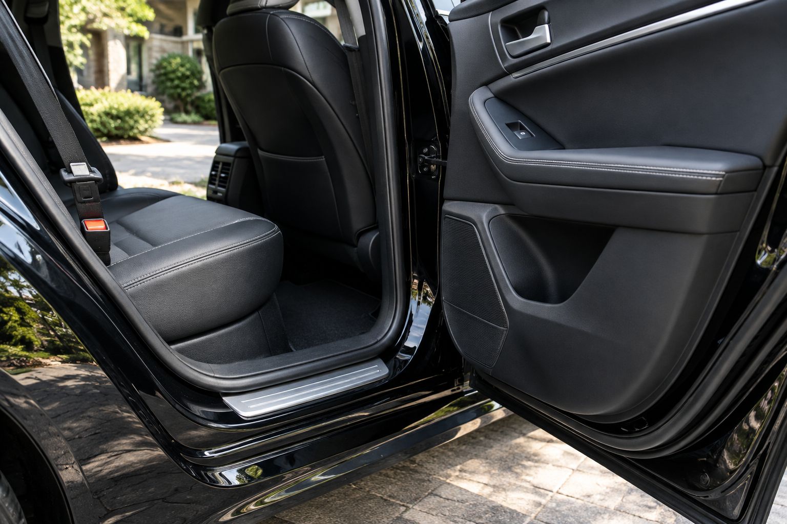 Clean rear passenger seat, seatbelt buckle, door sill, and lower door panel