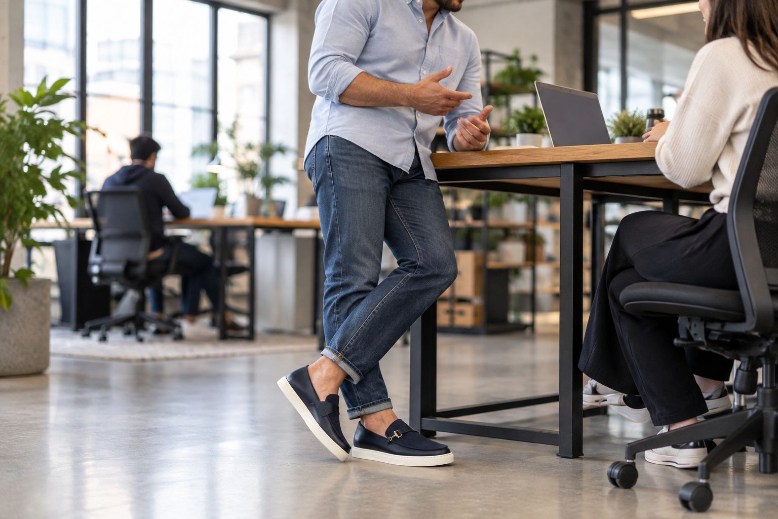 Man wearing navy suede Italian sneakers at a startup office desk