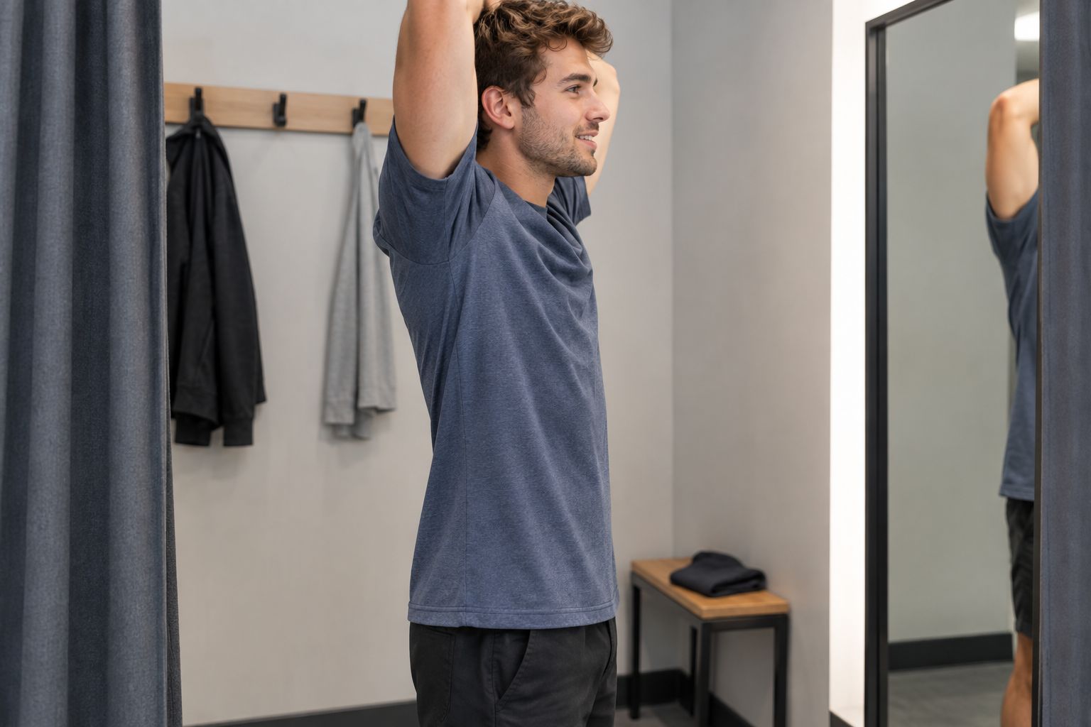 A person checking how a plain T-shirt moves when reaching overhead