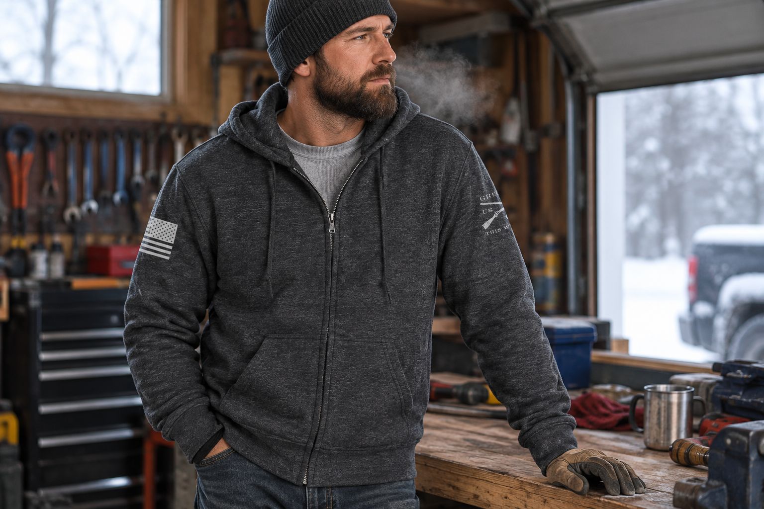 Man wearing a dark heather gray full-zip hoodie over a long sleeve in a cold garage