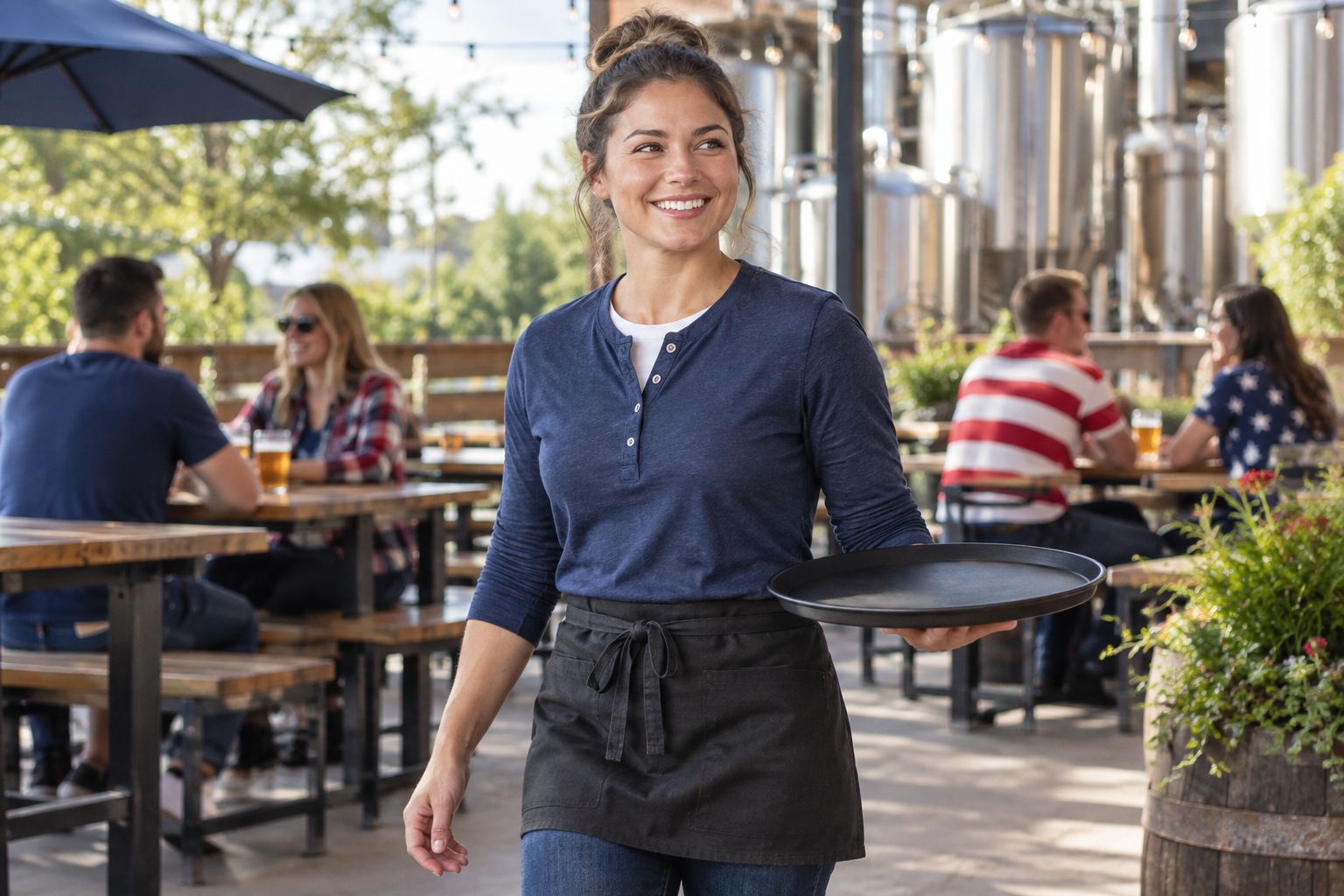 Taproom employee checking a henley layer with an apron and serving tray