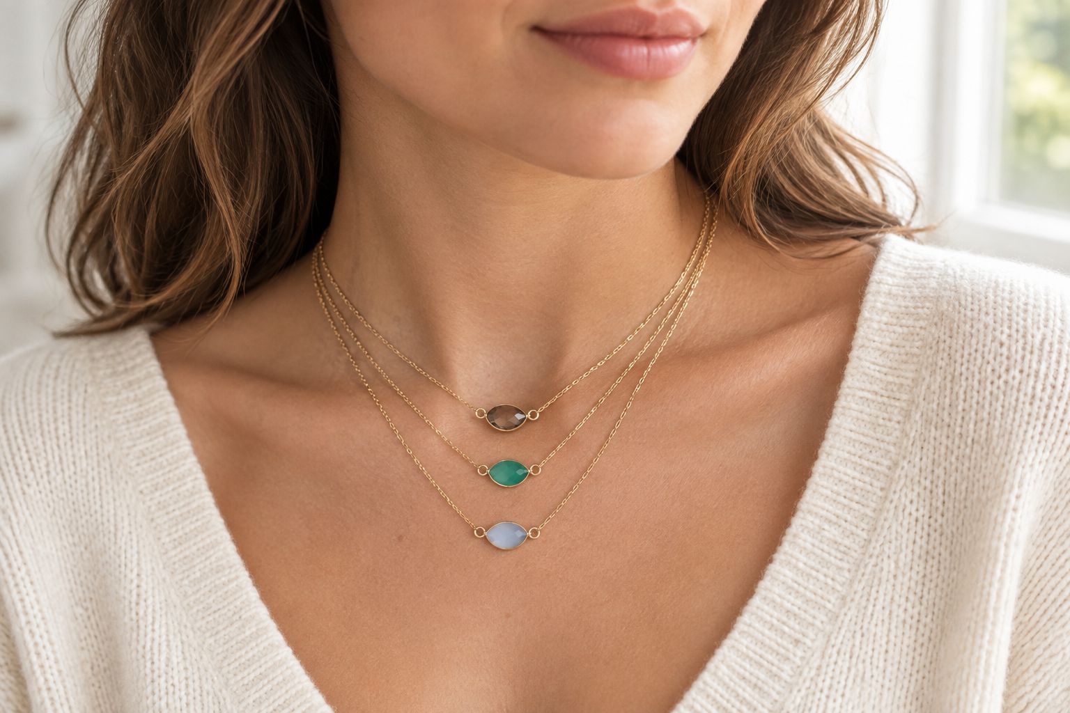 Delicate bezel-set gemstone necklaces layered at the collarbone