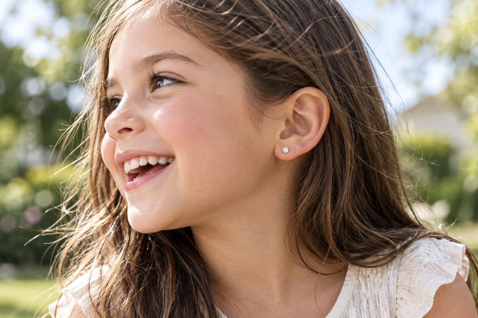 Young child playing outdoors wearing small stud earrings