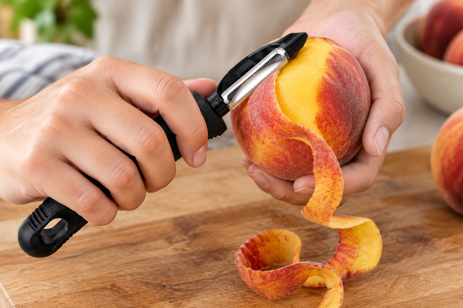 Serrated peeler removing skin from a ripe peach