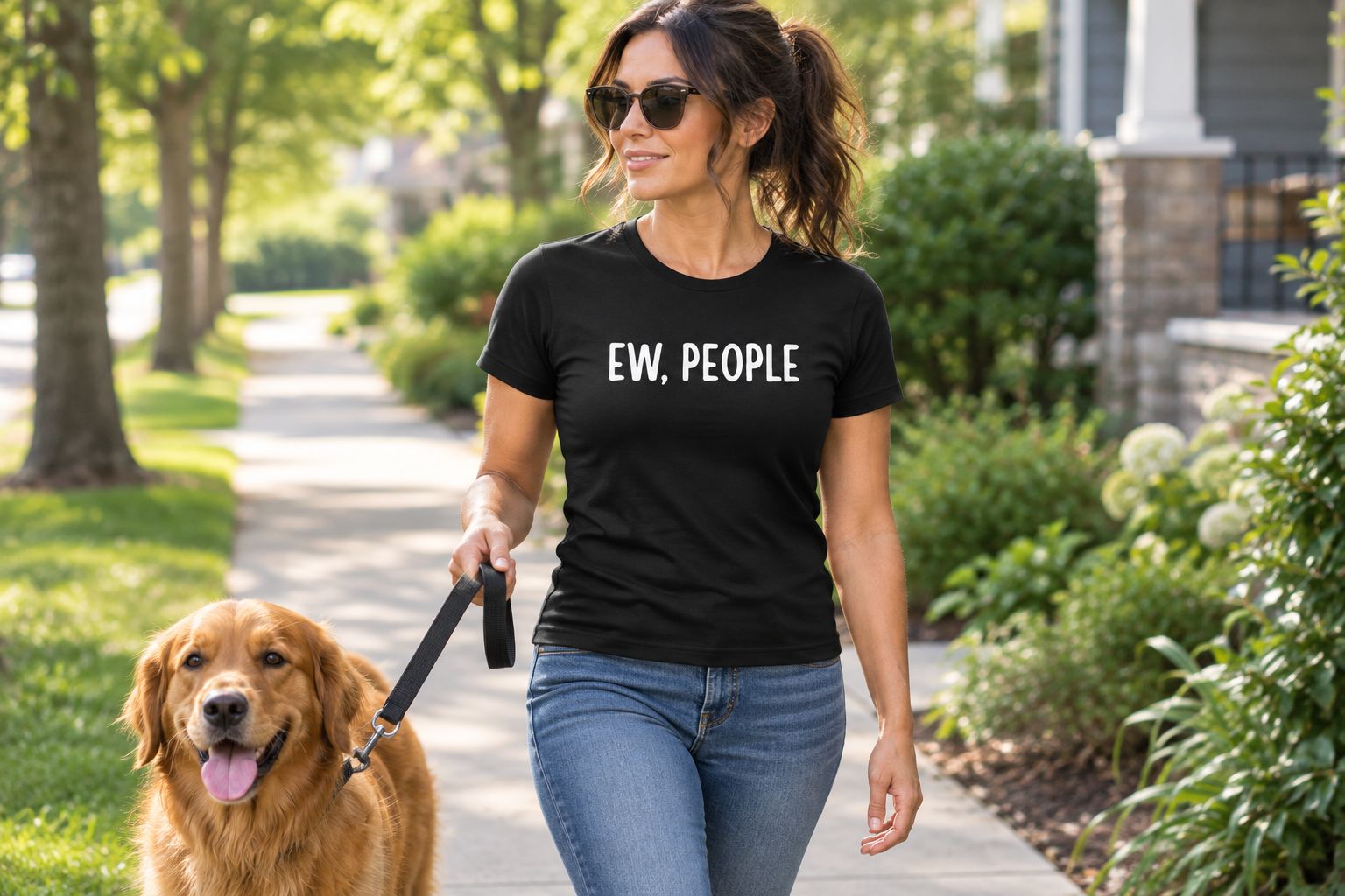 An adult wearing a people-averse graphic tee while walking a dog