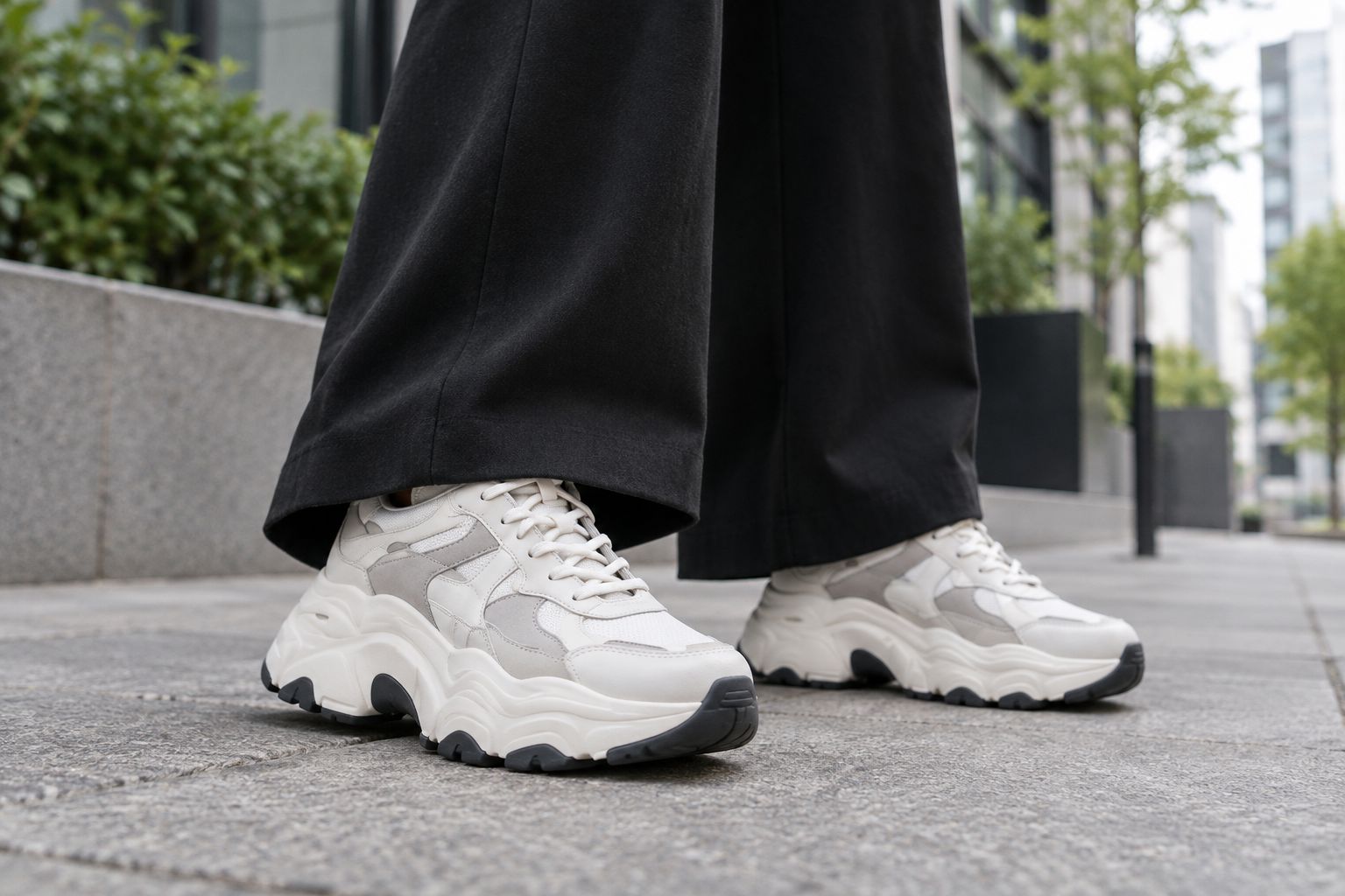 Chunky platform trainers with wide trousers on a city street