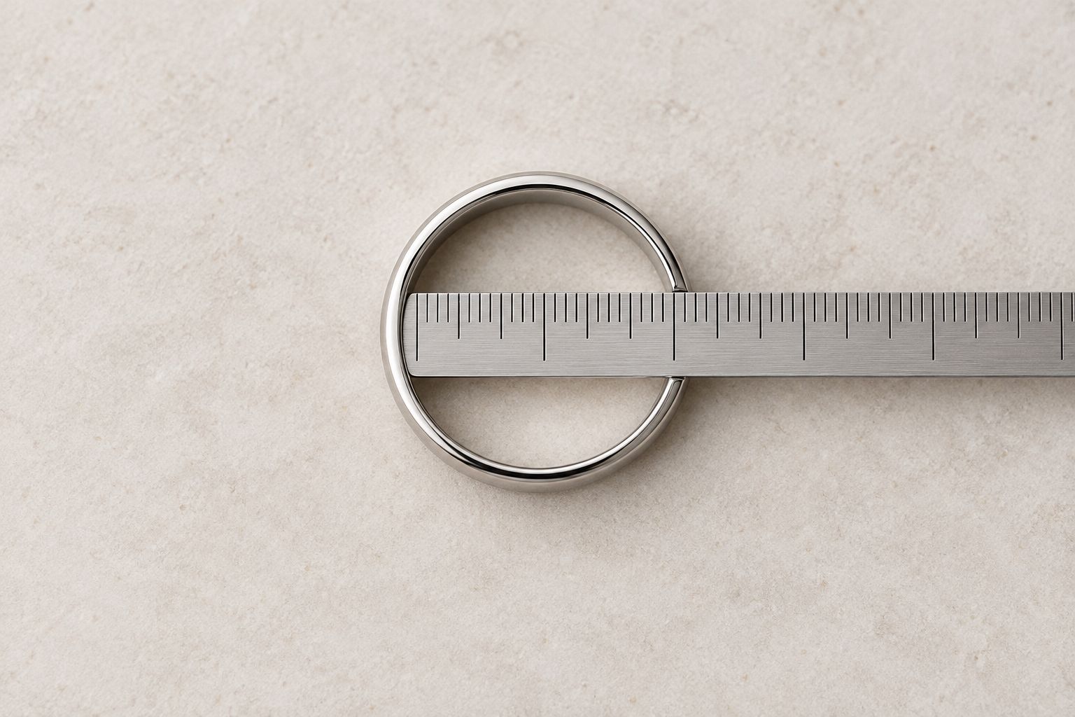 A plain ring with a ruler aligned across its inside opening