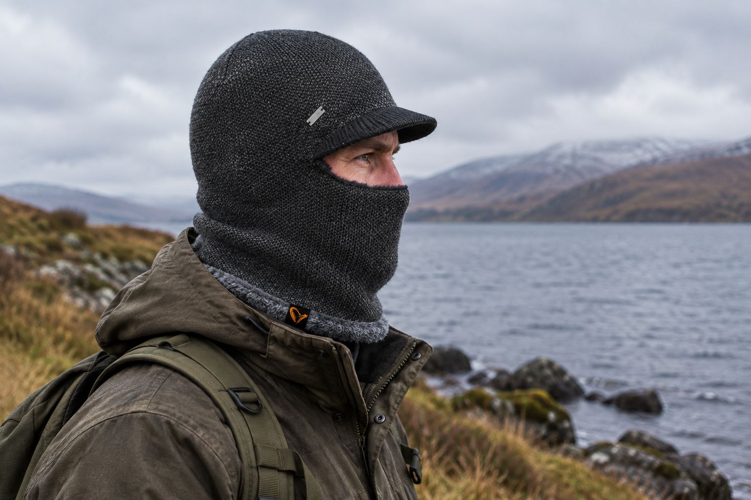 Balaclava worn with a jacket collar beside a lake on a cold day