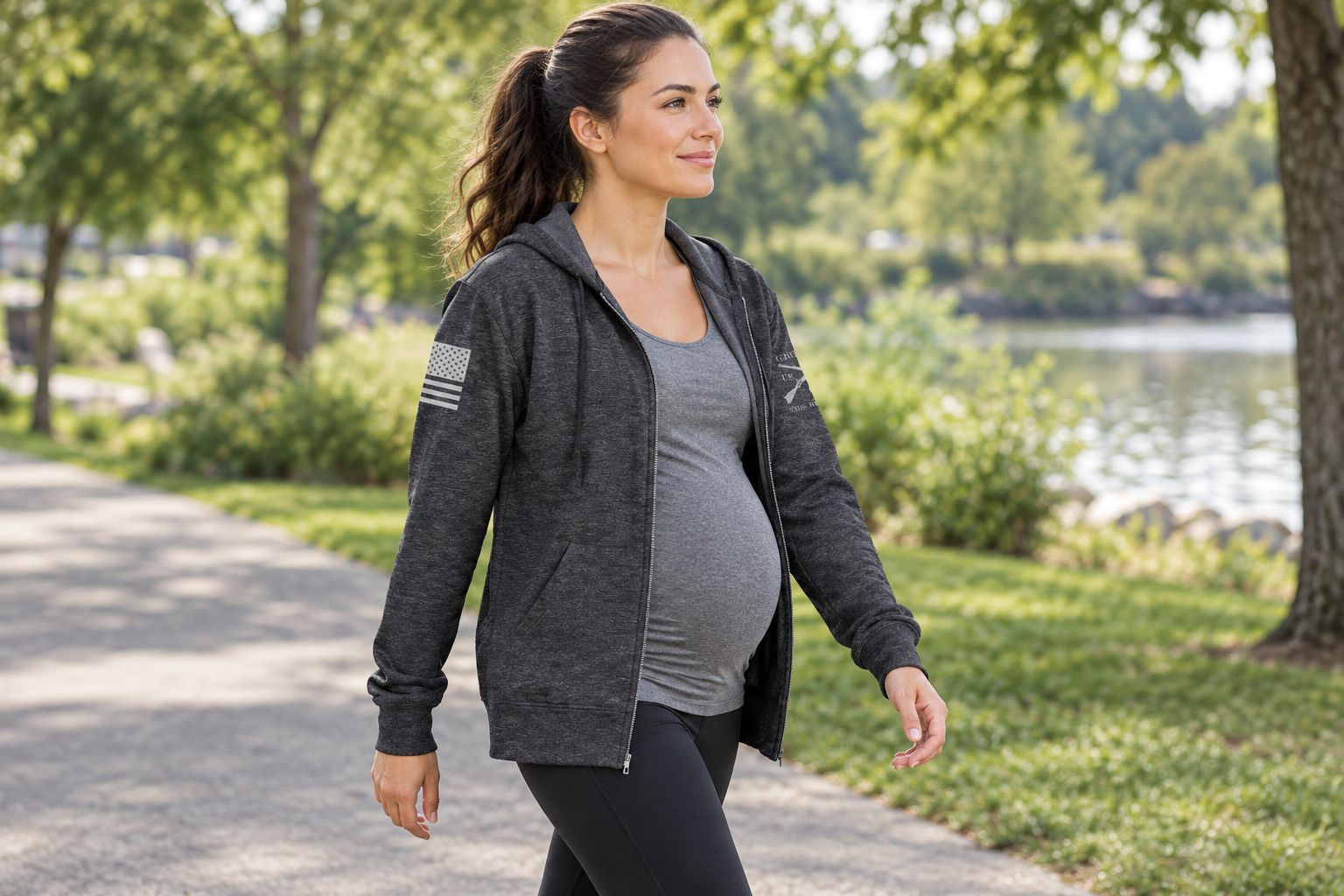 Pregnant walker wearing an open full-zip hoodie over a workout top
