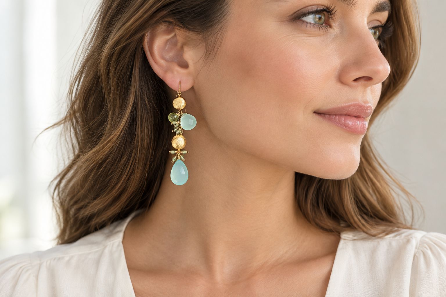 Aqua chalcedony and peridot earrings worn with a plain blouse and an uncluttered neckline