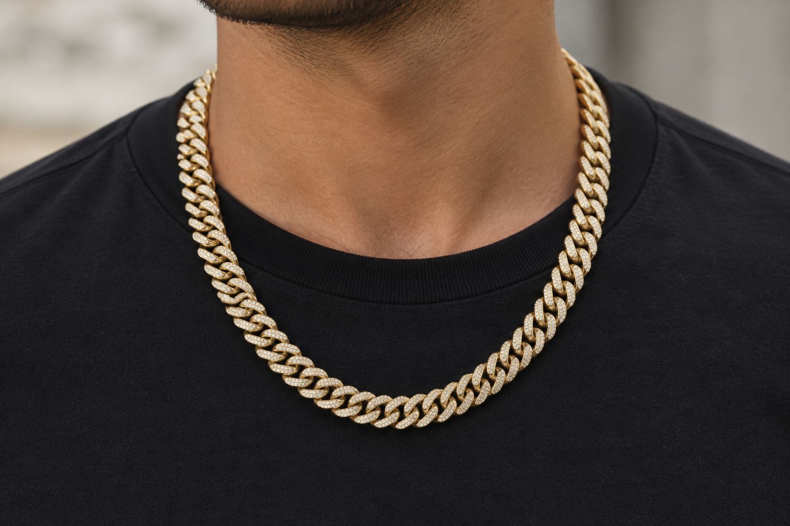A broad rounded-link moissanite necklace worn over a plain dark crew-neck shirt.